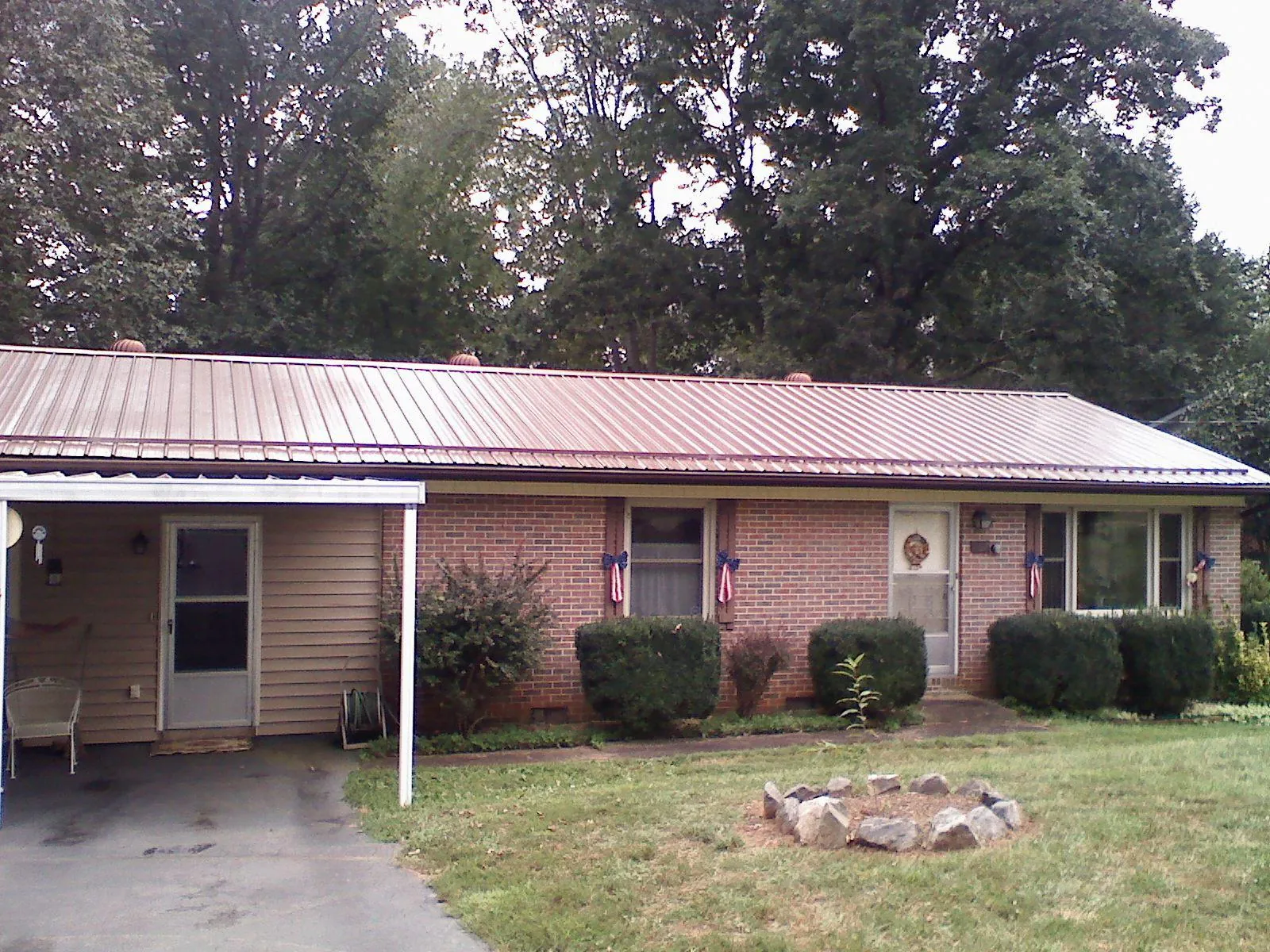 Bronze metal roof and carport on a brick ranch home — Roof Repair work by our crew in La Marque