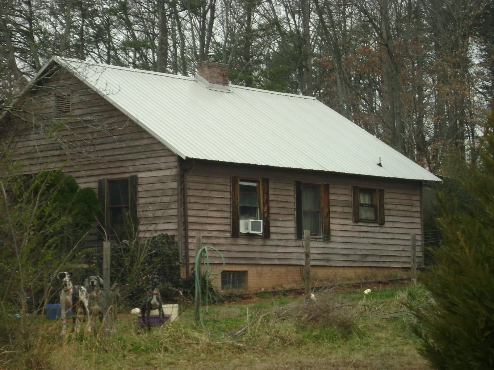 White metal roof on an old wood sided farmhouse, from a Metal Roof Installation job in La Marque